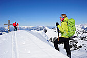Two backcountry skiers arriving at summit of mount Brechhorn, Kitzbuehel Alps, Tyrol, Austria