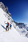 Young woman and young man ascending with crosscountry skis to notch Rote-Rinn-Scharte, backcountry tour, Kaiser-Express, Rote-Rinn-Scharte, Wilder Kaiser, Kaiser range, Tyrol, Austria