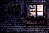 Window of a cottage in the mountains while a sunrise, Oberberg, Bavaria, Germany