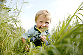 Boy (3 years) crouching on grass, Vienna, Austria