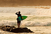 Hawaii, Maui, Kapalua, Local surfer standing on a rock checking the waves