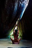 Caribbean, British Virgin Islands, Virgin Gorda, The Baths, The Crawl, Woman doing yoga in sea cave.