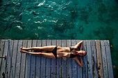 Woman lounging on resort pier.