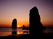 Oregon, Cannon Beach, Sea stacks near Haystack Rock at sunset.