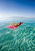 French Polynesia, Tahiti, Moorea, Woman floating in water.