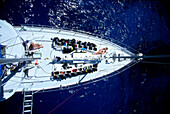 Woman sunbathing on deck of sailboat, view from above mast dive tanks, overview A16B