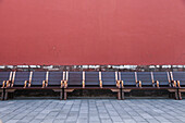 Benches run along a wall inside the Forbidden City in Beijing, China., Beijing, China. Forbidden City seating