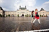 Two girls walking through the Red Square in front of the GUM