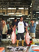 FIshermen and workers at an open air fish market in Johor, Malaysia