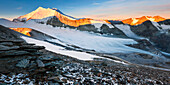 View from Barrhorn to sunrise above the Brunegg Glacier and the peaks of the Weisshorn Mountain Range in autumn, Valais, Switzerland