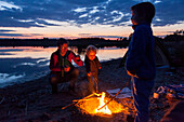 Family at campfire, Werbeliner See, Saxony, Germany