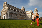 Paar läuft auf den Rasen vor dem Dom, Duomo, Torre pendente, Schiefer Turm, Piazza dei Miracoli, Piazza del Duomo, UNESCO Weltkulturerbe, Pisa, Toskana, Italien, Europa