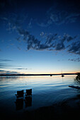 Two folding chairs in lake Starnberg in twilight, Bavaria, Germany