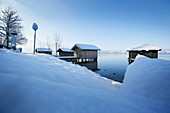Snow-covered boathouses at lake Kochel, Upper Bavaria, Germany