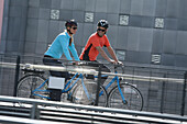 Couple riding e-bikes, Munich, Bavaria, Germany