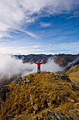 Wanderer steht auf dem Gipfel vom Deneck, Schladminger Tauern, Steiermark, Österreich