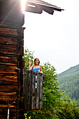 Mädchen steht auf einem Balkon und winkt, Steiermark, Österreich