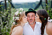 Two young women kissing a fruit farmer, Riegersburg, Styria, Austria