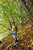 Junge Frau läuft durch einen Herbstwald, Steiermark, Österreich