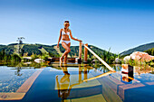 Junge Frau an einem Pool, Almwellness Hotel Pierer, Fladnitz an der Teichalm, Steiermark, Österreich