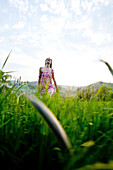 Young woman walking through high grass, Riegersburg, Styria, Austria