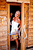 Junge Frau steht in der Tür einer Sauna, Fladnitz an der Teichalm, Steiermark, Österreich