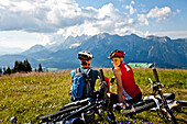 Two mountain bikers resting on a meadow, Duisitzkar, Planai, Styria, Austria