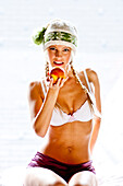 Junge Frau mit Mütze hält einen Apfel, Steiermark, Österreich