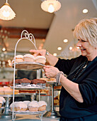 USA, California, Los Angeles, Owner Joan Mcnamara arranging cupcakes in her cafe Joan's On Third.