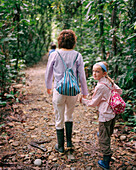 PERU, Amazon Rainforest, South America, Latin America, cute girl holding mother's hand while walking in the Amazon Rainforest.