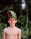 PERU, Amazon Rainforest, South America, Latin America, portrait of Asa with a bird costume made of leaves and flowers.