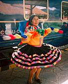 PERU, Cusco, South America, Latin America, mature woman in traditional clothing performing in front of the Hiram Bingham Train. The train travels from Cusco to Aguas Calientes and back.