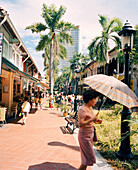 SINGAPORE, Asia, woman walking with umbrella on Bussorah street