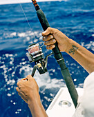 USA, Florida, man reeling fishing rod, close-up, Islamorada