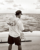 USA, Florida, fisherman prepping casting net to catch bait fish, Islamorada (B&W)