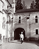 FRANCE, Burgundy, chef walking in courtyard outside Abbaye De La Bussiere Restaurant and Hotel, Dijon (B&W)