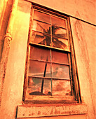 USA, Hawaii, Oahu, the North Shore, a palm tree and sunset reflect in the window of a building that was an old convent