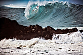USA, Hawaii, Oahu, a surfer dropping in on a large wave at Waimea Bay, The North Shore