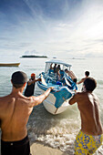 INDONESIA, Mentawai Islands, Kandui Surf Resort, surfers loading a boat to go surfing for the day, Indian Ocean