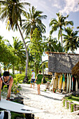 INDONESIA, Mentawai Islands, men and woman walking outside Kandui Resort