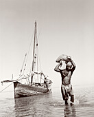 MADAGASCAR, man carrying supplies, Nosy Be (B&W)