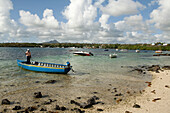 MAURITIUS, Trou D'eau Deuce, fisherman Rolau Dardenne (age 80) prepares his boat to go fishing off of the East coast of Mauritius, Indian Ocean, 4 Sisters Mountain in the distance