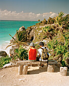MEXICO, Maya Riviera, couple sitting on bench at the Tulum Ruins