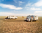MONGOLIA, Nemegt Basin, after a day of riding camels the riders end at a campsite and dinner in the Gobi desert