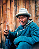MONGOLIA, Khuvsgul National Park, a horseman Bayambasuren smokes a cigarette by Khuvsgul Lake, Toilogt Ger Camp
