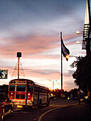 NICARAGUA, Grenada, traffic driving through downtown with the Nicaraguan flag in the distance