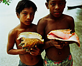 PANAMA, Bocas del Toro, Salt Creek Islands, Guaymi Indian boys hold colorful shells, Central America