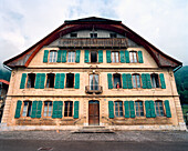 SWITZERLAND, Bouvresse, an elderly woman Jaquline Petit-Pierre looks out the window of an old pensione, Jura Region