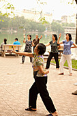 VIETNAM, Hanoi, women practice Tai Chi early in the morning, Hoan Kiem Lake