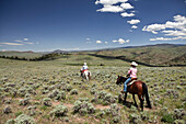 USA, Wyoming, Encampment, a cowboy and cowgirl ride through an endless landscape, Abara Ranch